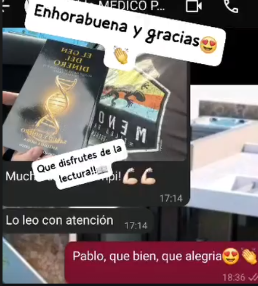 Manos sosteniendo un libro junto a una taza en una mesa cálida